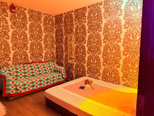Gold damask treatment room with massage bed and sofa